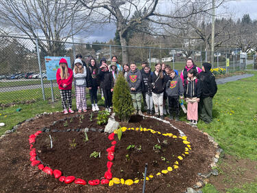 Group of students stand at the newly planted garden