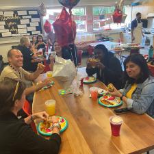 Group of support staff sitting down enjoying starbucks and treats